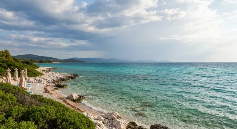 Spokojna plaża w Ksamili na Riwierze Albańskiej w październiku z morzem i chmurami