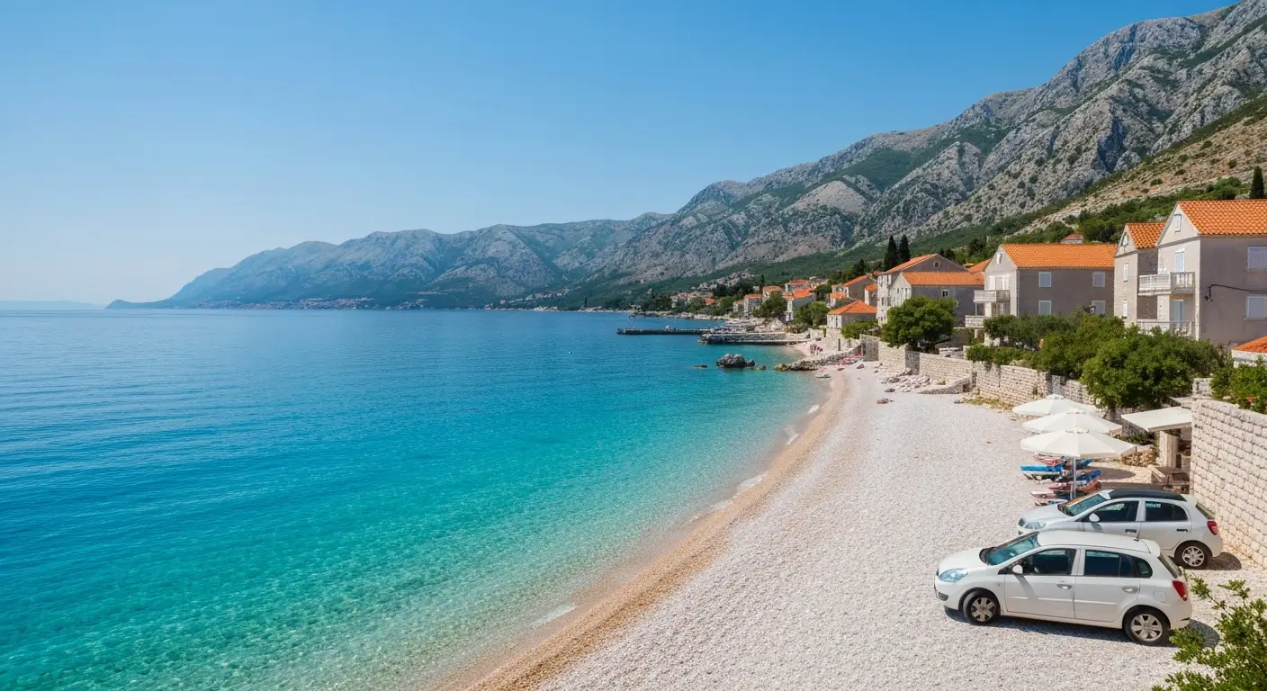 Kamienista plaża nad Adriatykiem z wapiennymi górami i dalmatyńską zabudową