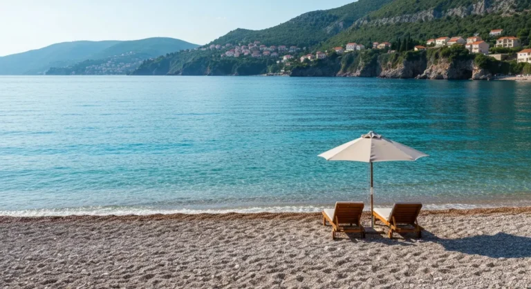 Spokojna kamienista plaża w Bečici z ciepłym Adriatykiem i wzgórzami Riwiery Budwańskiej